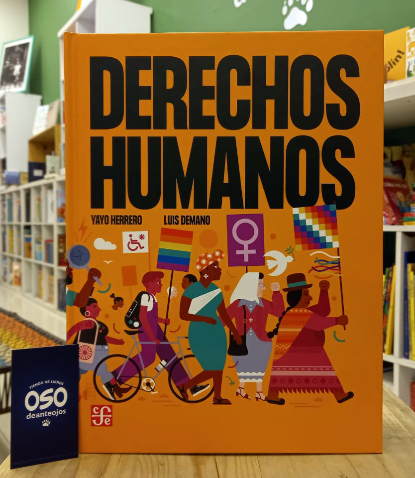 Fotografía del libro "Derechos Humanos" de Yayo Herrero y Luis Demano. La portada es de color naranja brillante con letras negras grandes. Muestra una ilustración colorida y diversa de una manifestación con personas que llevan banderas (LGBT, feminista, wiphala) y símbolos de accesibilidad y paz. A la izquierda, una tarjeta azul con el logotipo de la librería "Oso de anteojos"